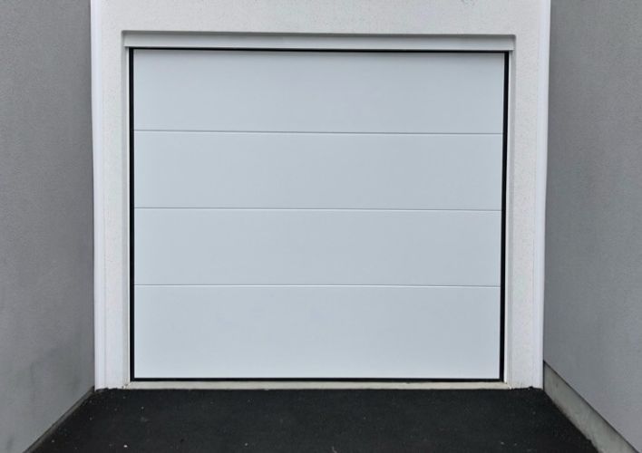 Porte de garage sectionnelle plafond blanc.