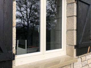 Fenêtres et portes-fenêtres en PVC beige avec croisillons gravés.