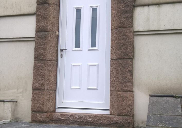 Porte d'entrée blanche cintrée en PVC.